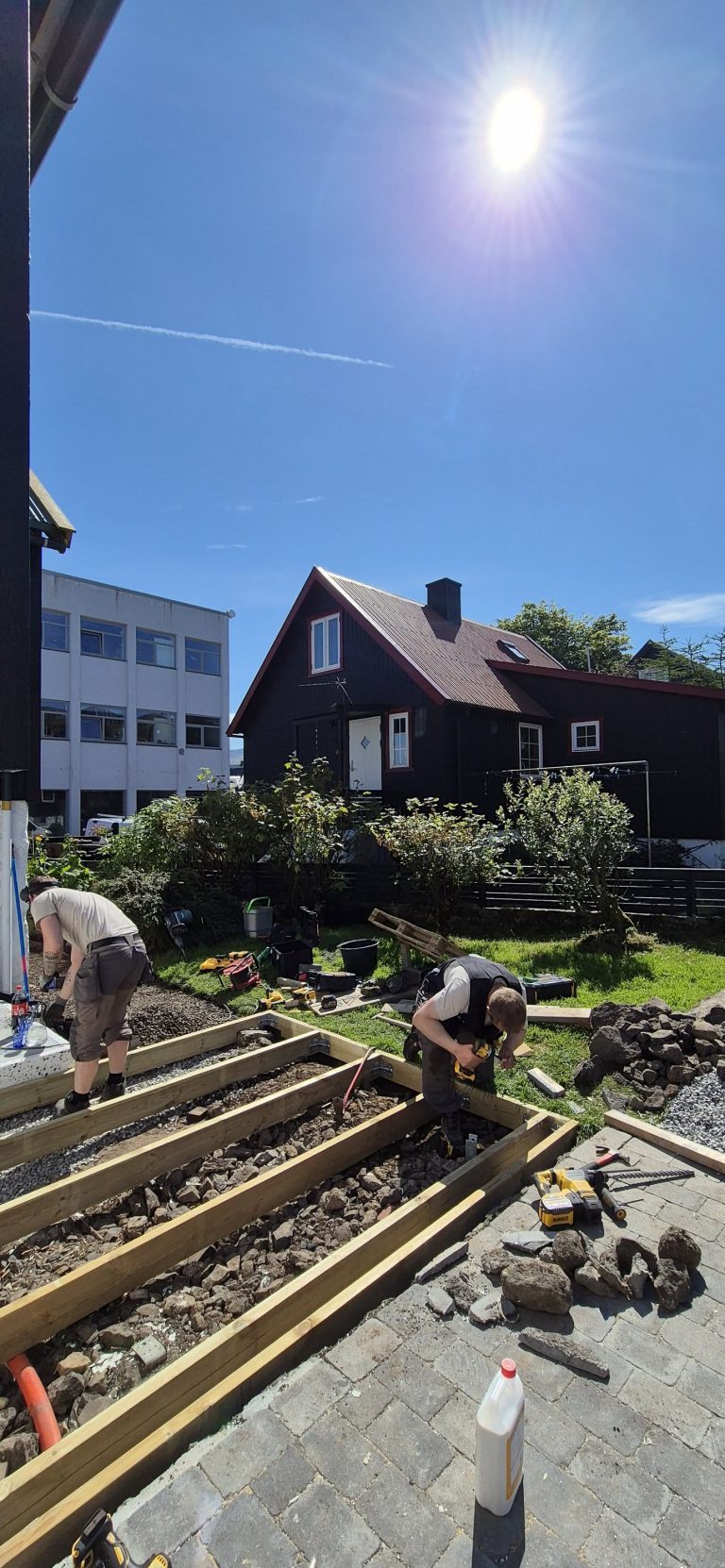 Snikkarar byggja timburgrindina til eina nýggja terassu í einum garði